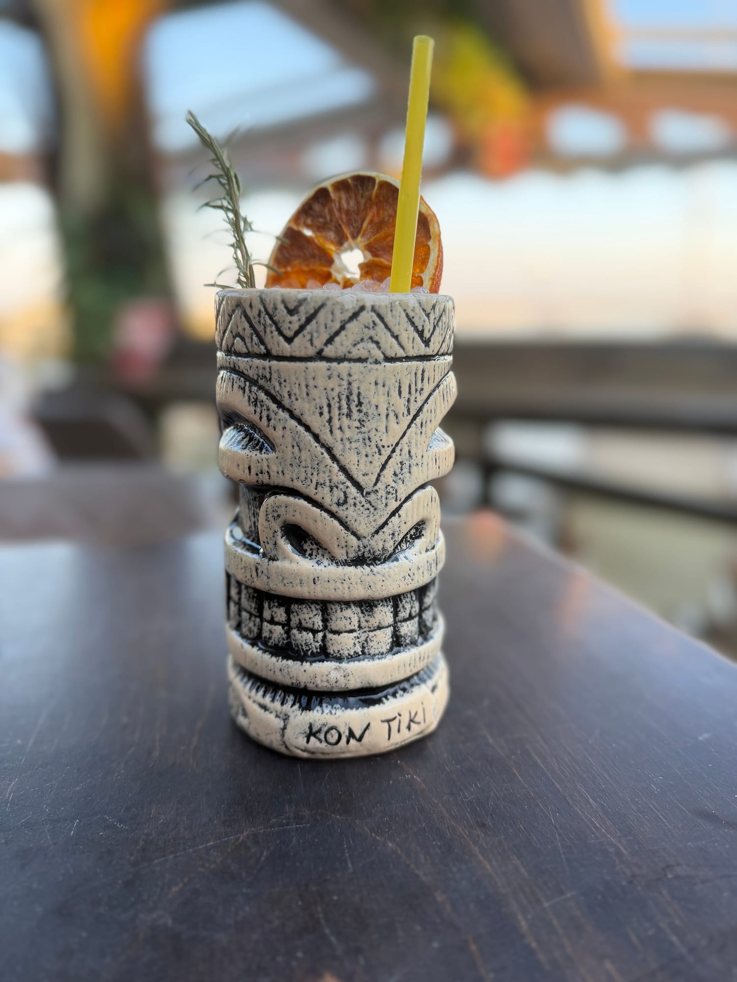 Kon Tiki mug cocktail with rosemary and dried orange at golden hour